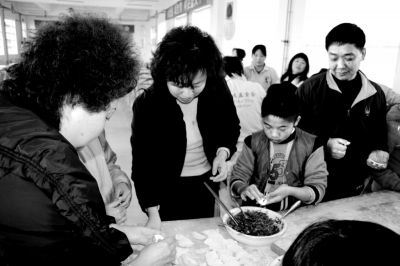 郑州市儿童福利院院长李燕(右三)与福利院的孩子一起包水饺过冬至
