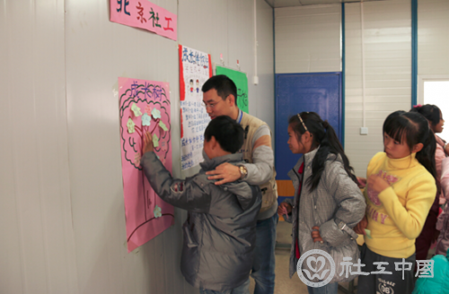 服务队队员郑阔引导学生参与“沟通心开始”小组活动。