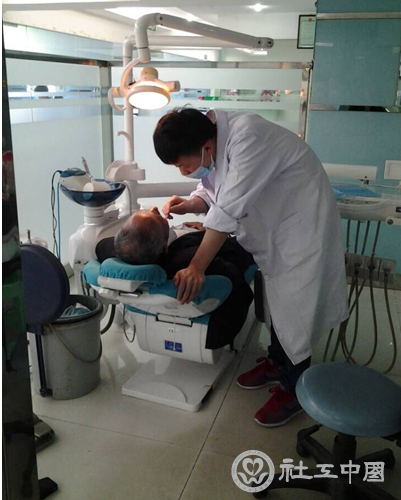 图为牙科医师为两位老人治疗牙齿