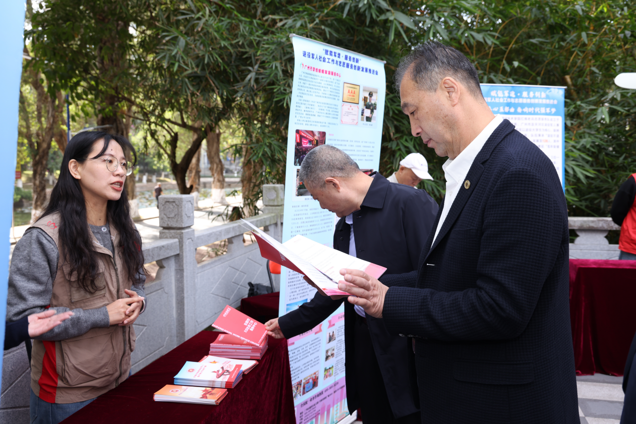图：广州市挚缘婚姻家庭服务中心工作人员向主办方介绍退役军人社会服务